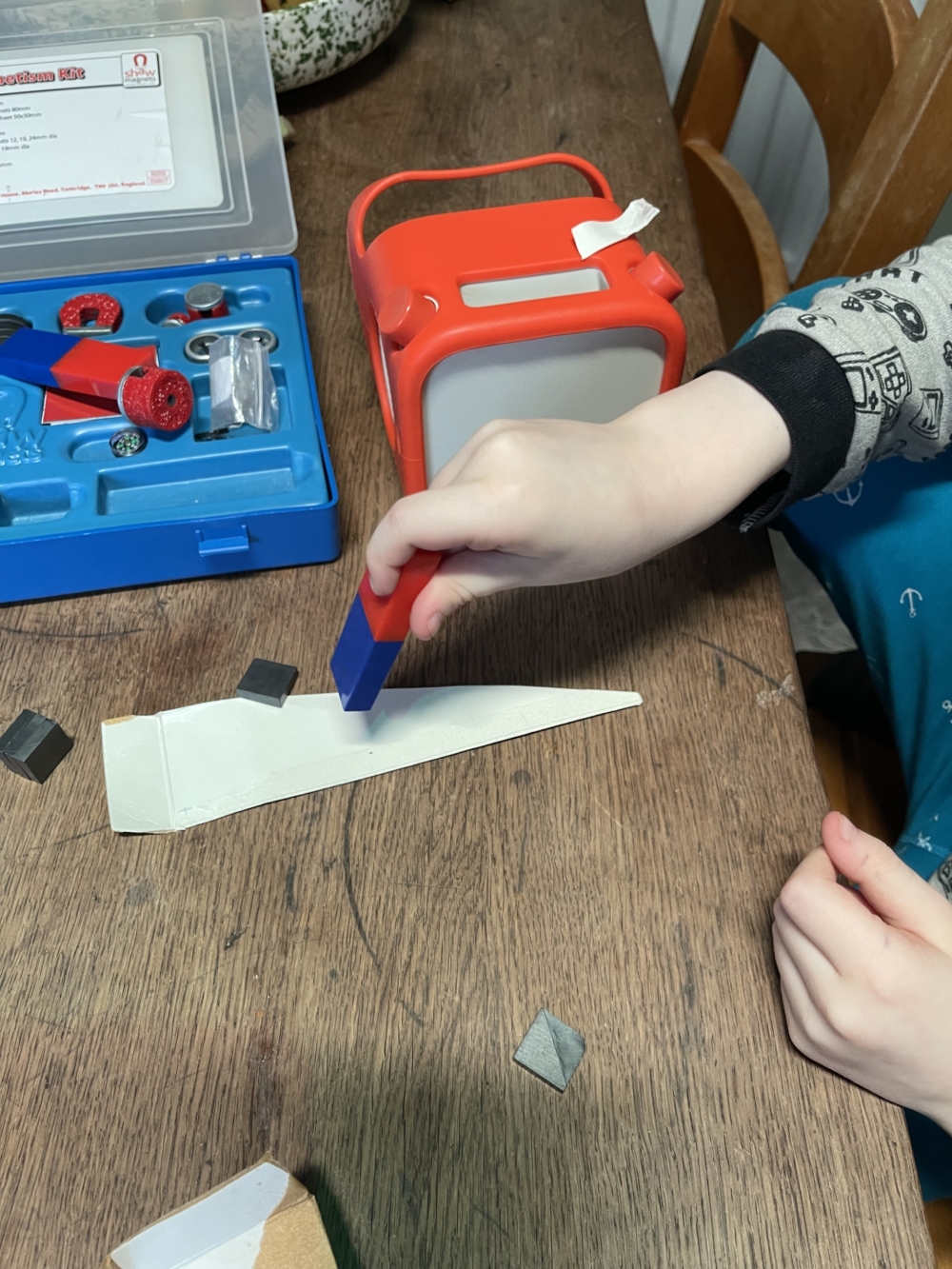 Luke is trying out his magnet on a piece of paper.