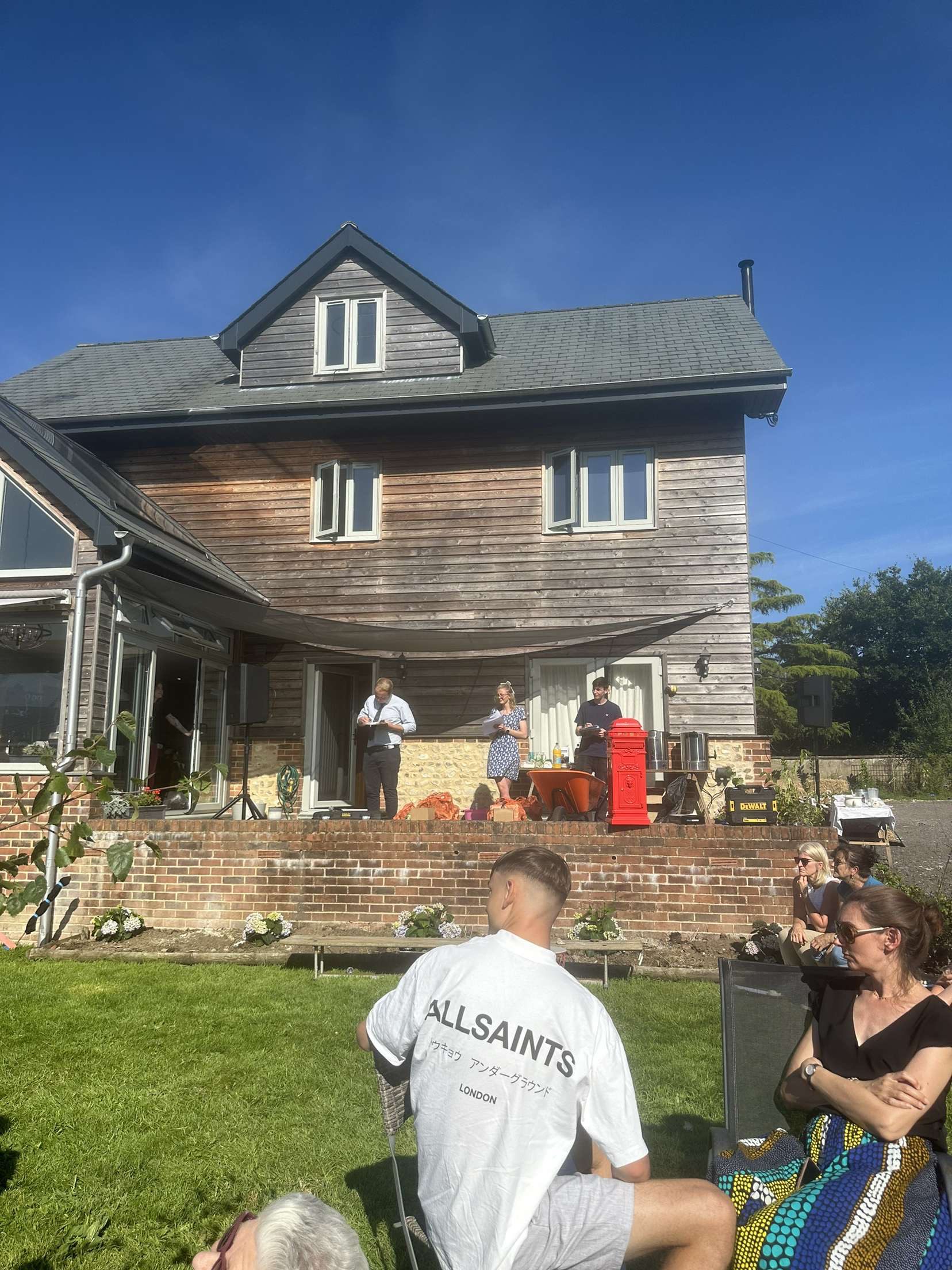 Standing on the house terrace giving a speech to the guests