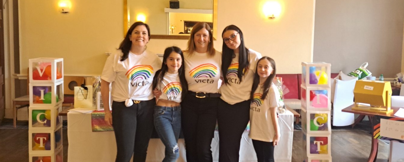 Lesley and family smiling in VICTA tshirts