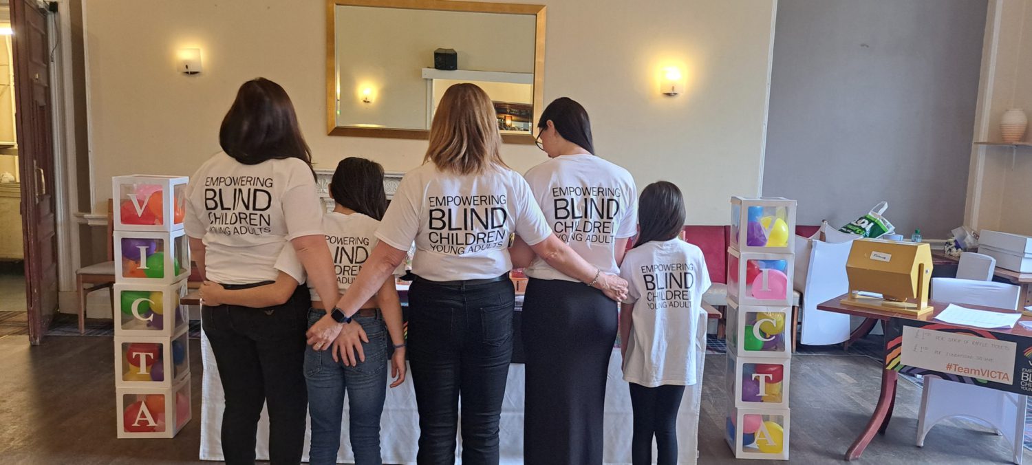 The group with their backs to camera so you can read the empowering blind children message